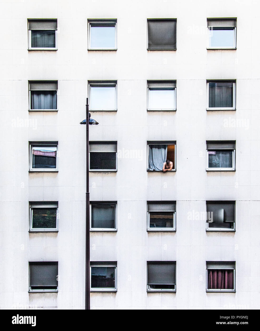 Man in the window of an apartment building, Paris, France Stock Photo