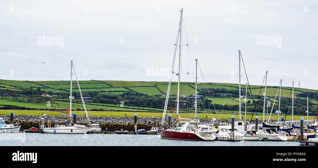 Dingle, Kerry/ Ireland - September 22, 2018: yachts and boats moored in  the Dingle harbor with Irish countryside across the bay Stock Photo