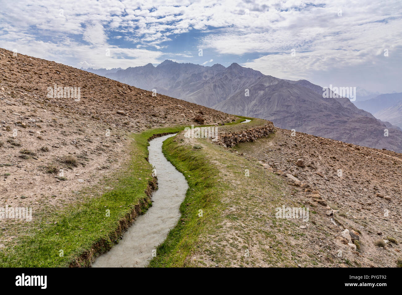 Typical traditional Central Asian water canal, or water dyke carrying water to villages, Langar, Tajik Wakhan, Pamir Mountains, Tajikistan Stock Photo