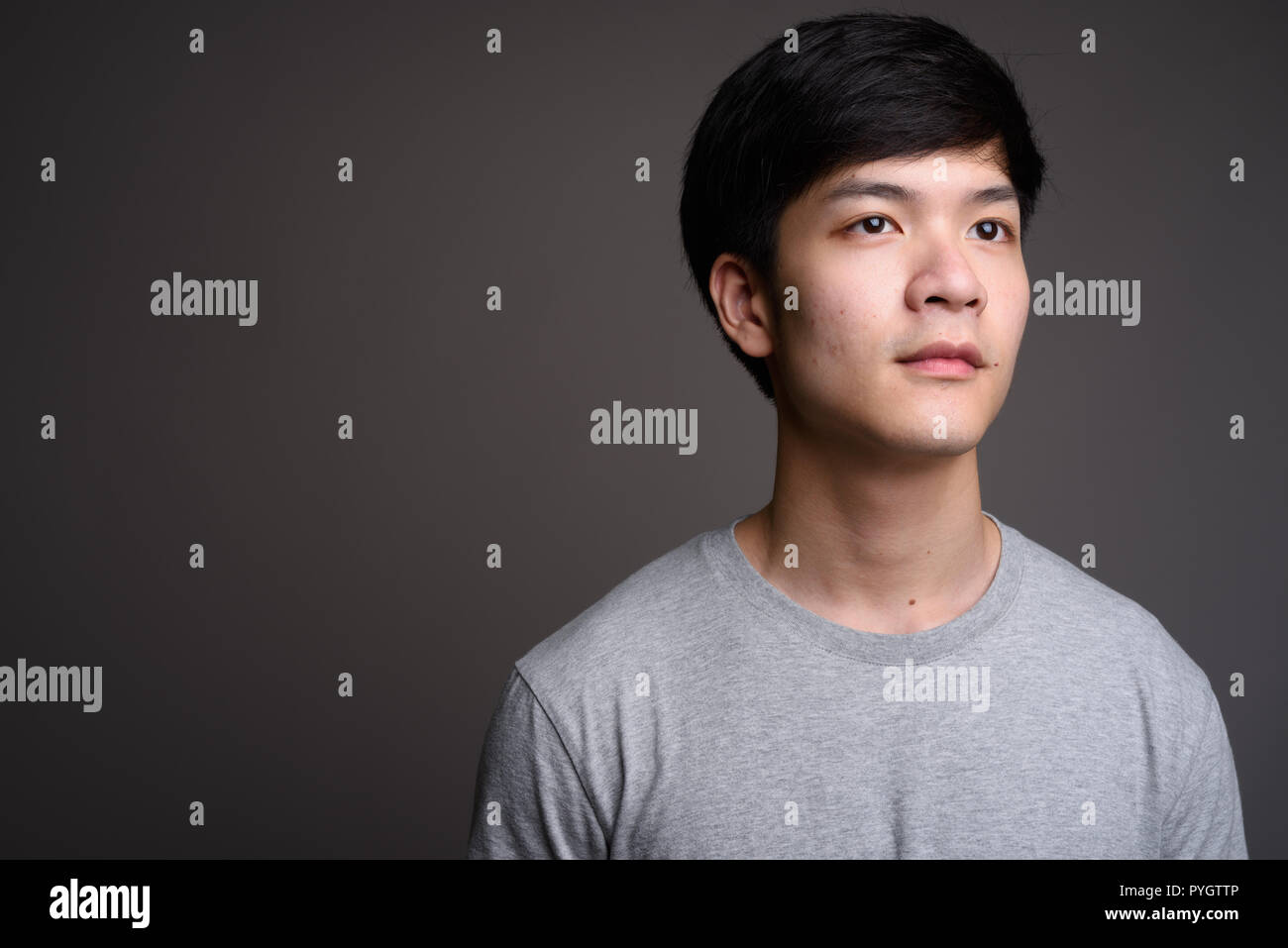 Young Handsome Asian Man Thinking Against Gray Background Stock