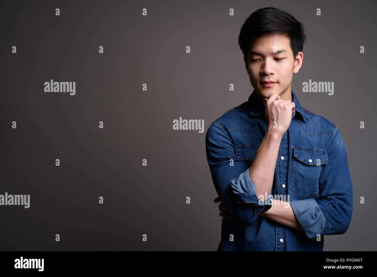 Young handsome Asian man wearing denim shirt Stock Photo
