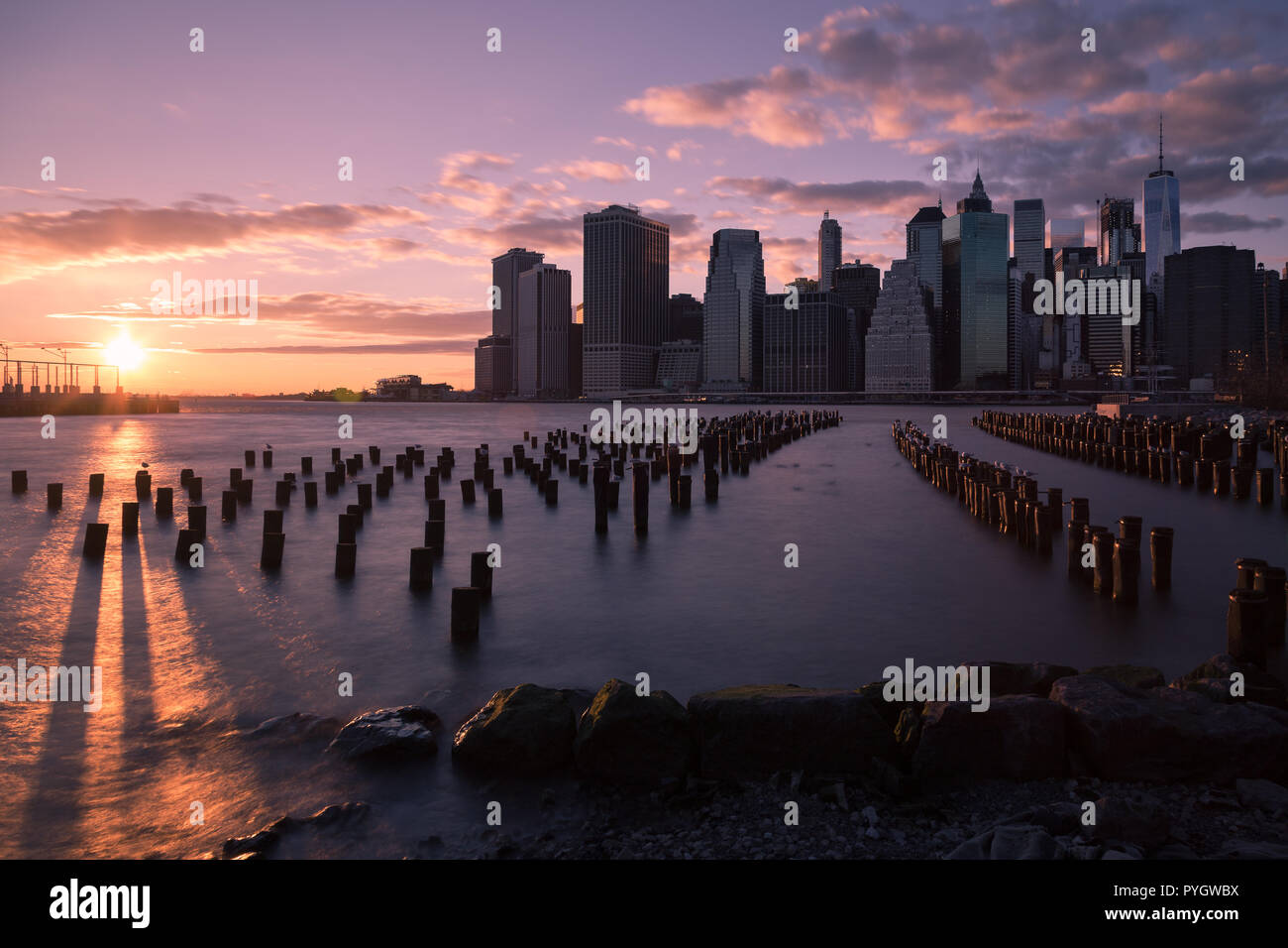 sunset in Manhattan, NY; seen from Brooklyn Bridge Park, skyline lower Manhattan while sunset Stock Photo