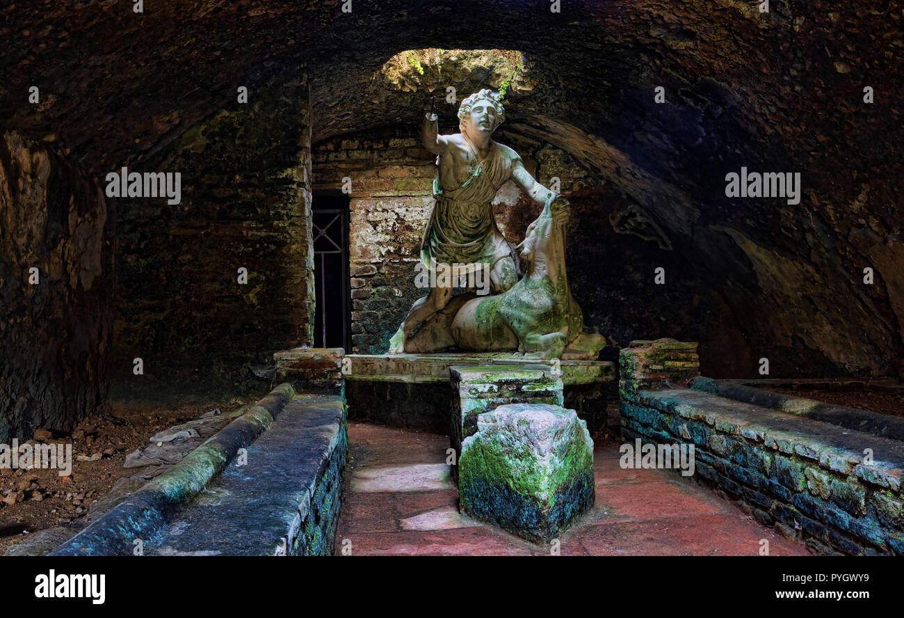 Statue of the god Mithras killing a bull in the thermal s mithraeum in archaeological excavations of Ostia Antica - Rome Stock Photo