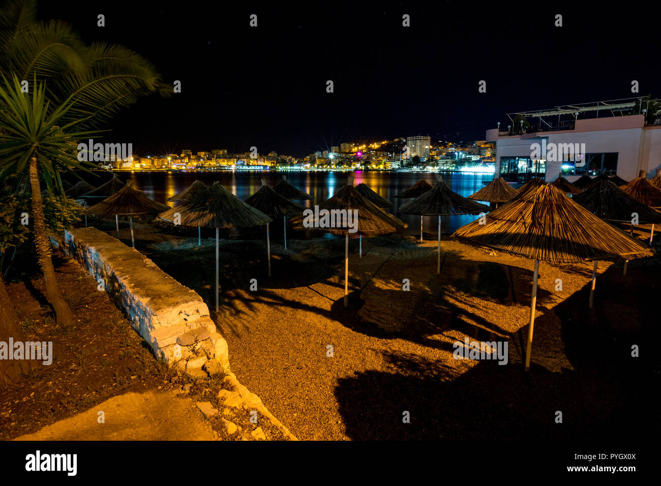 Long exposure night landscape photo, cityscape at the beautiful sea town of Saranda, Albania with star effect of the city lights and sea water reflections Stock Photo
