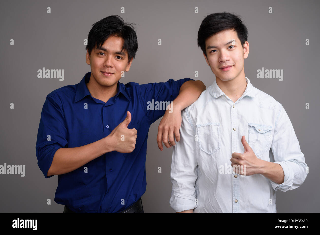 Portrait of two young handsome man giving thumb up Stock Photo