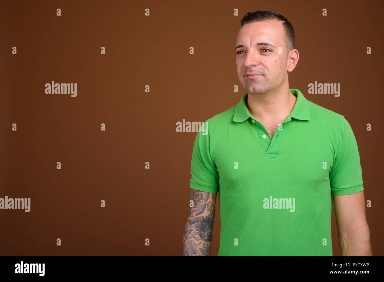 Man wearing green shirt against brown background Stock Photo