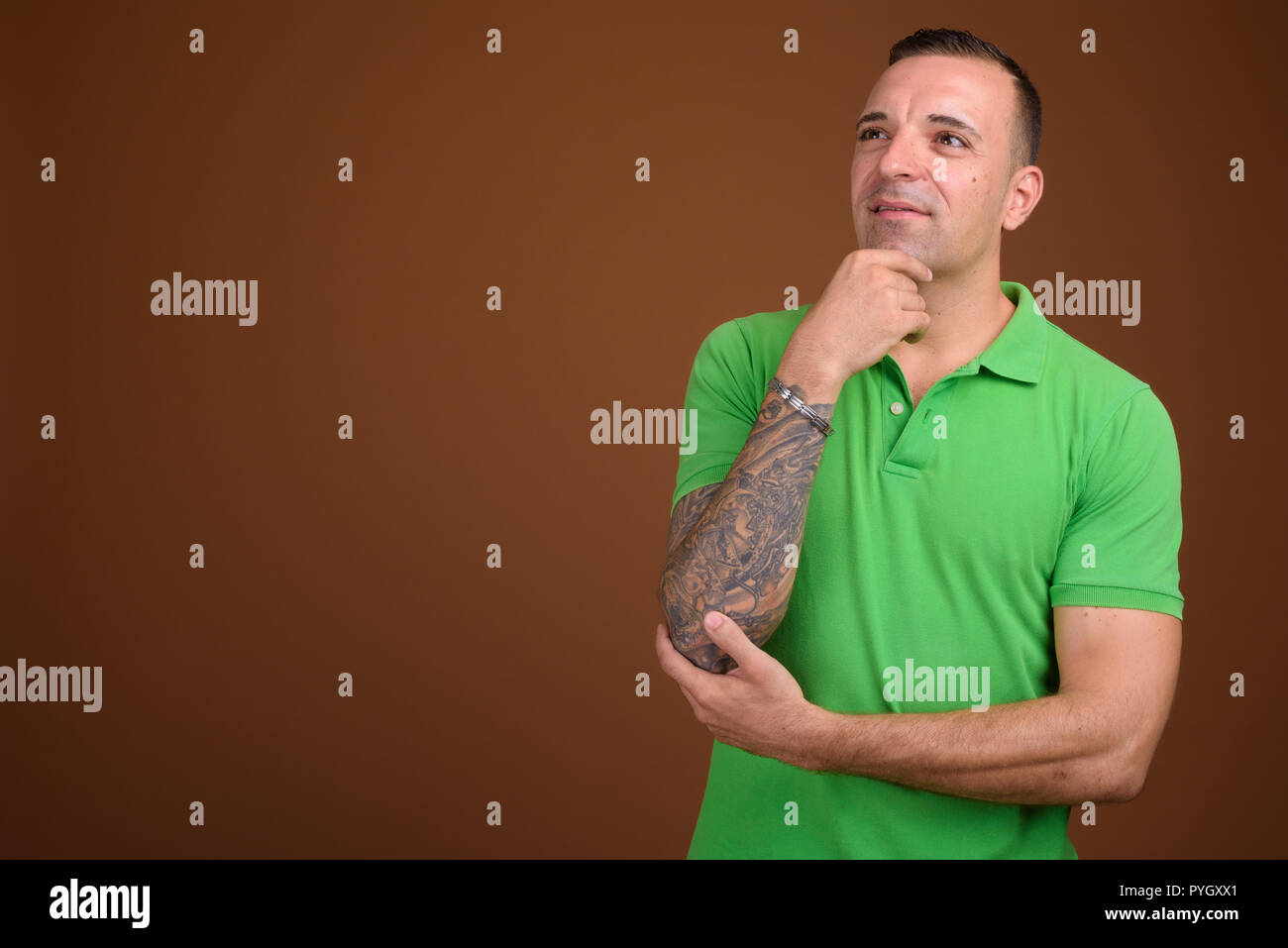Man wearing green shirt against brown background Stock Photo
