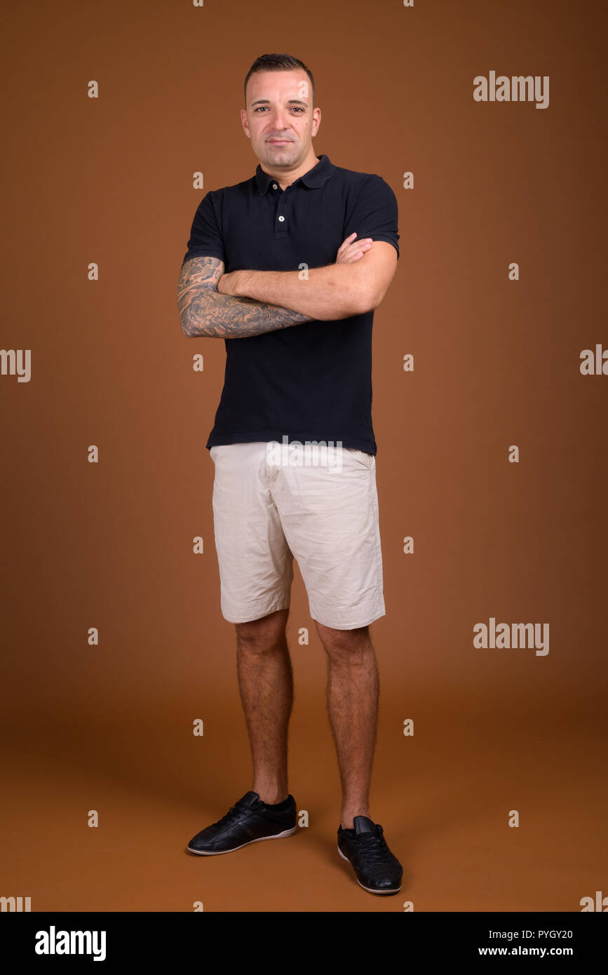 Man wearing black shirt against brown background Stock Photo
