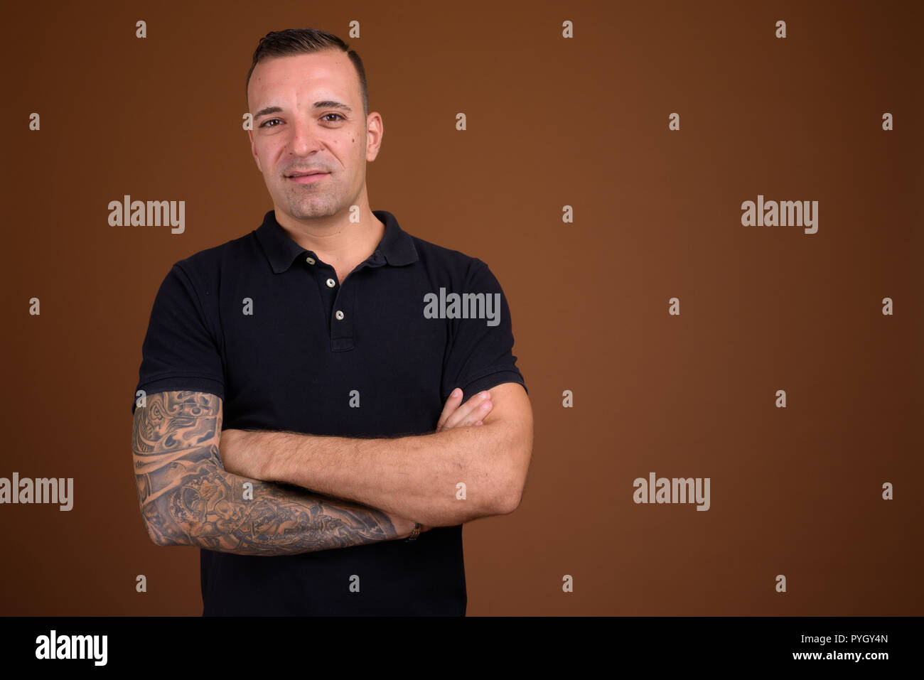 Man wearing black shirt against brown background Stock Photo