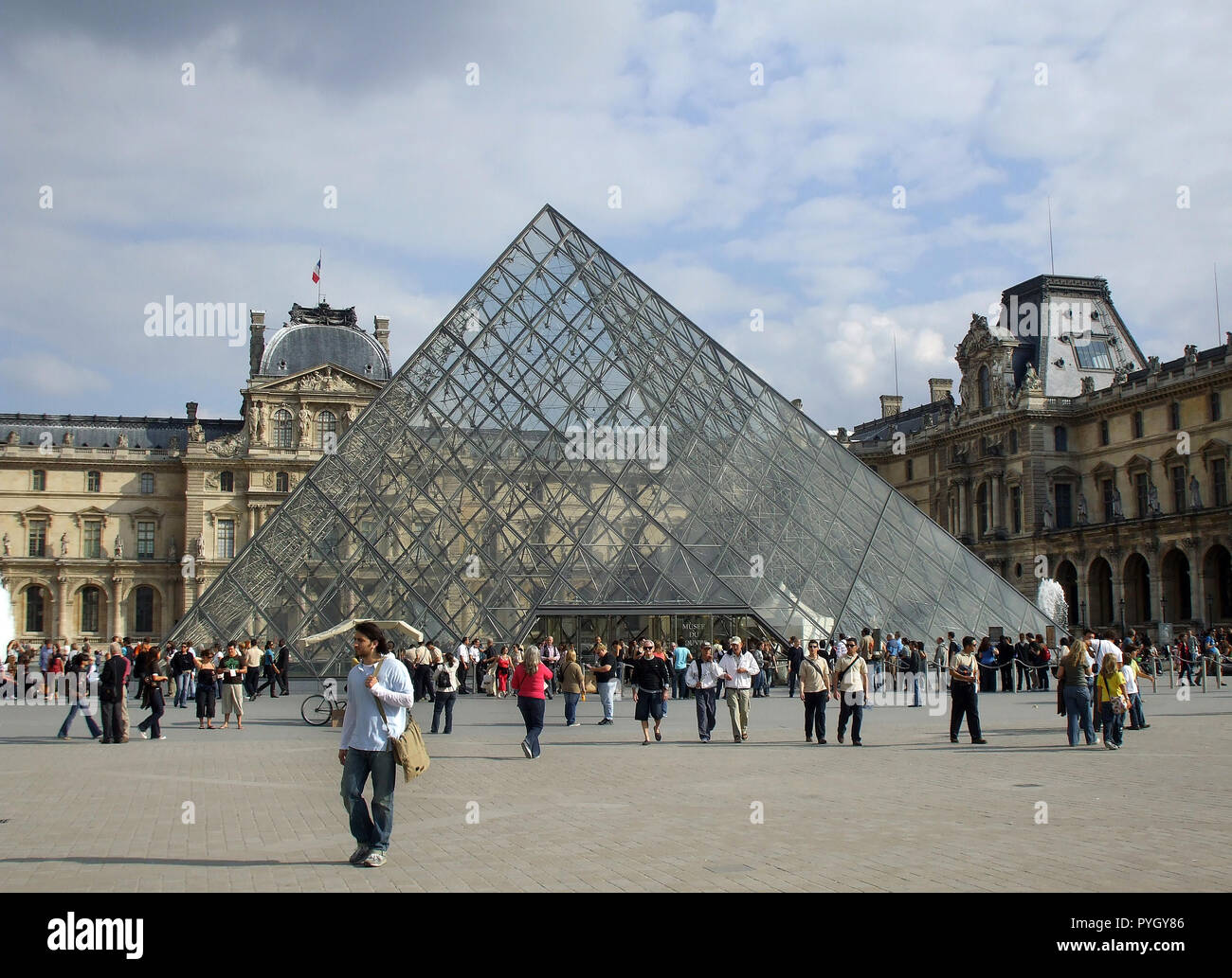 The main entrance to the Louvre museum is this famous, and stunning,  glass and metal pyramid in the main quadrant of the art gallery in Paris, France. Stock Photo