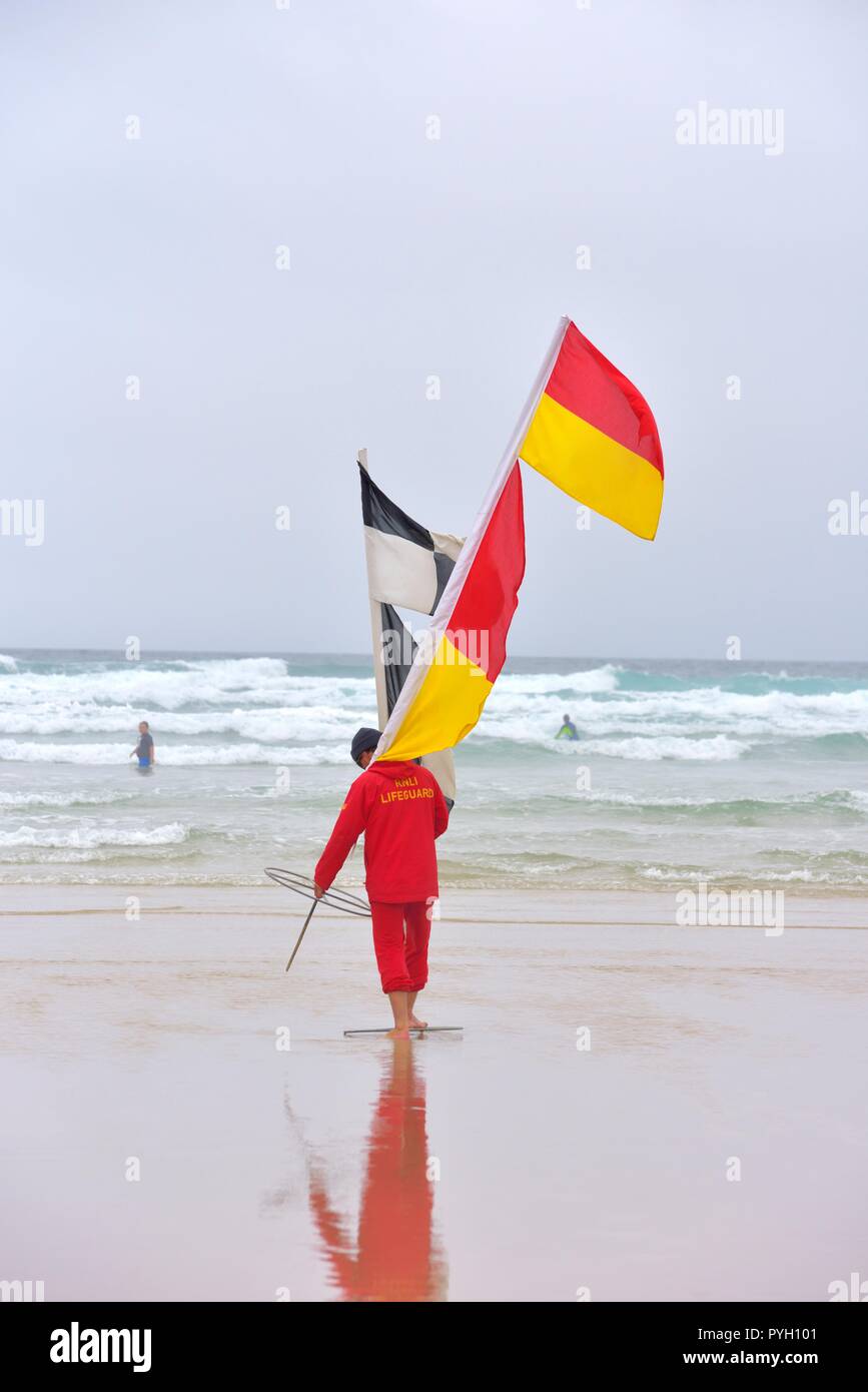 RNLI Lifeguard carrying safety warning flags Stock Photo