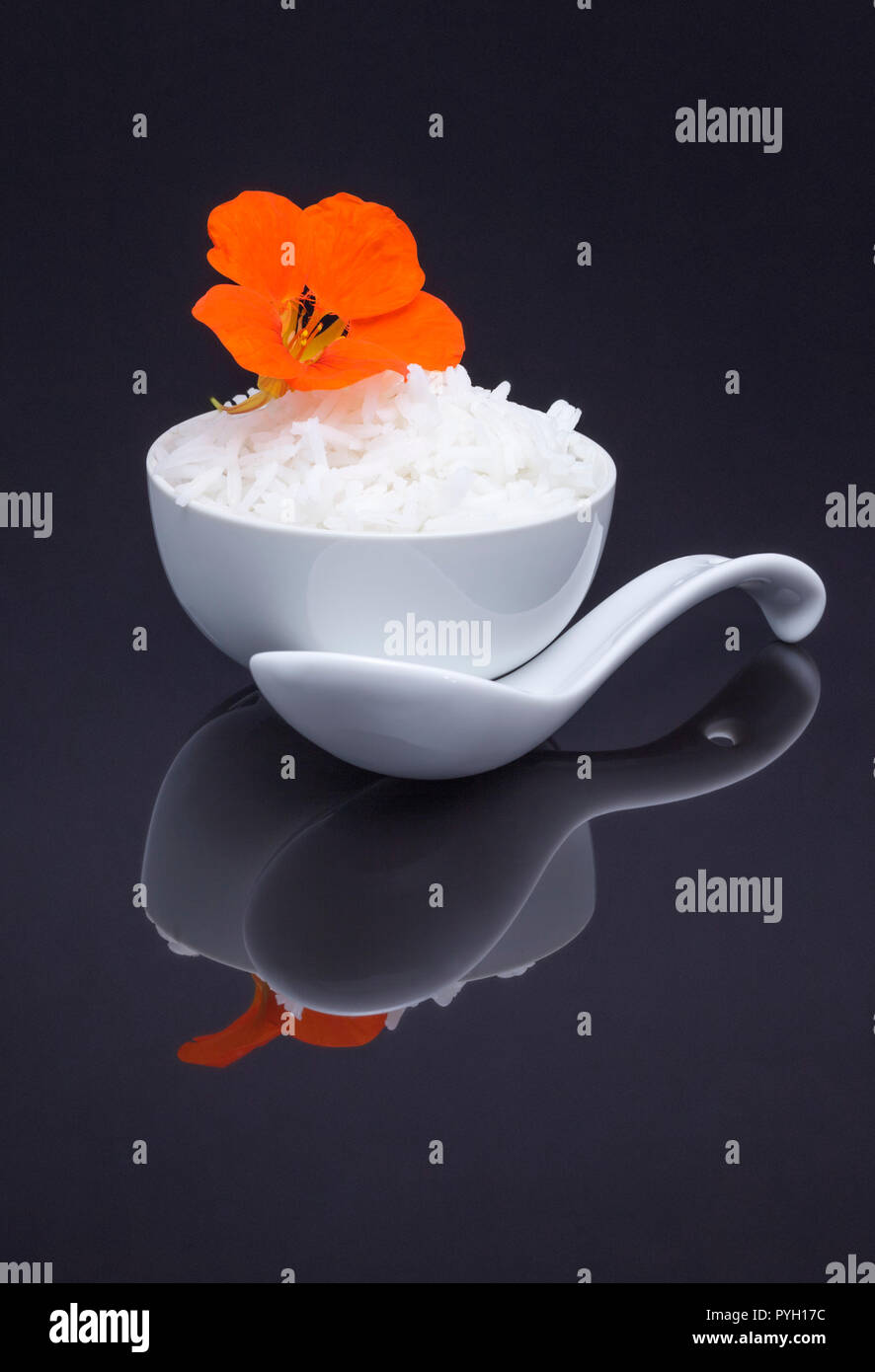 Bowl of white rice garnished with edible nasturtium Stock Photo