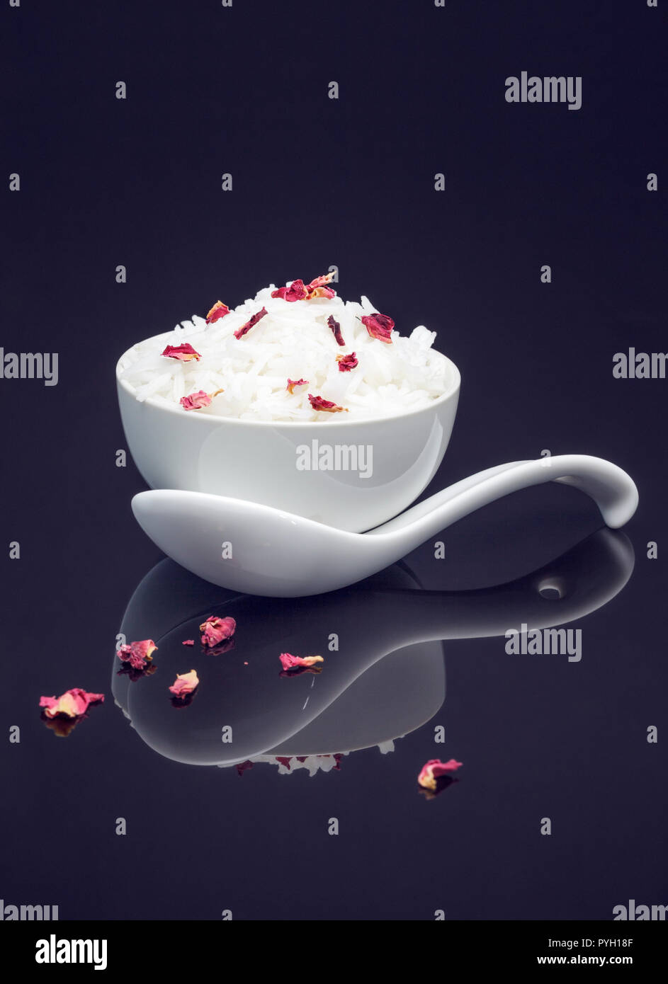 Bowl of white rice garnished with edible dried rose petals Stock Photo