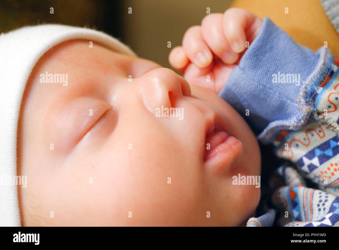 The baby sleeps sweetly with his mouth open. The child raised his hand to his face. Quietly dozing Stock Photo