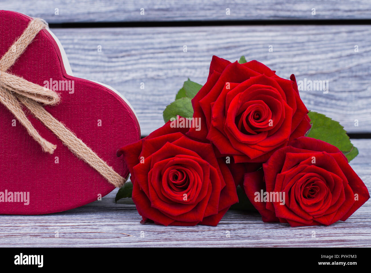 Blooming Rose Flowers And Gift Box Three Red Roses And Heart Shaped Gift Box On Wooden Background Birthday Surprise Concept Stock Photo Alamy