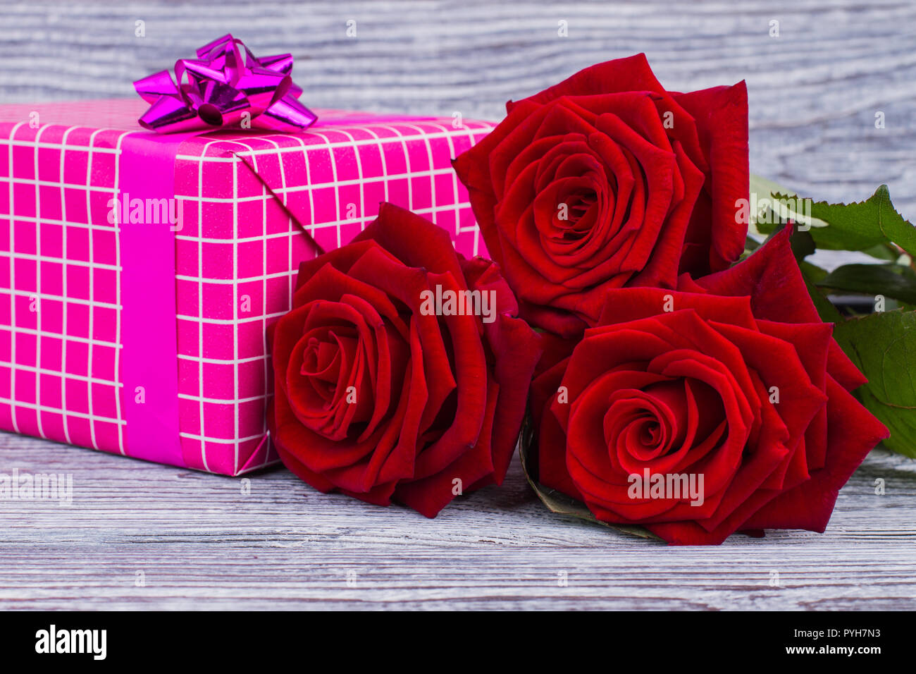Red roses and gift box close up. Pink present box and blooming flowers on rustic wood. Happy Valentines Day. Mothers Day background Stock Photo - Alamy Red roses and gift box close up. Pink present box and blooming flowers on rustic wood. Happy Valentines Day. Mothers Day background Stock Photo - Alamy
