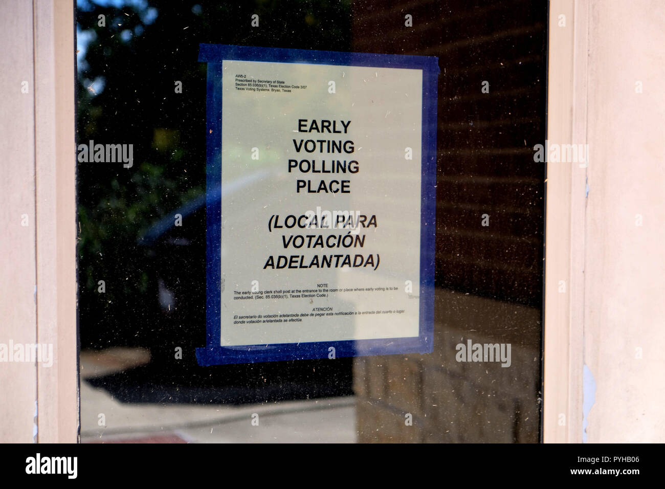 Bilingual English-Spanish sign on a glass for an Early Voting Polling Place; 2018 midterm elections, College Station, Texas, USA. Stock Photo