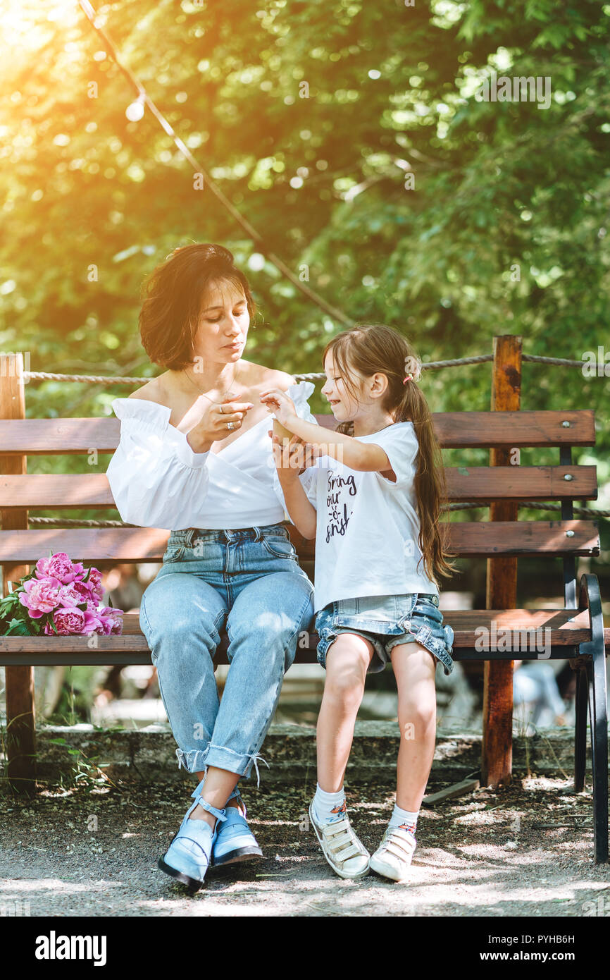 Mom and her little daughter on a bench in the park Stock Photo - Alamy