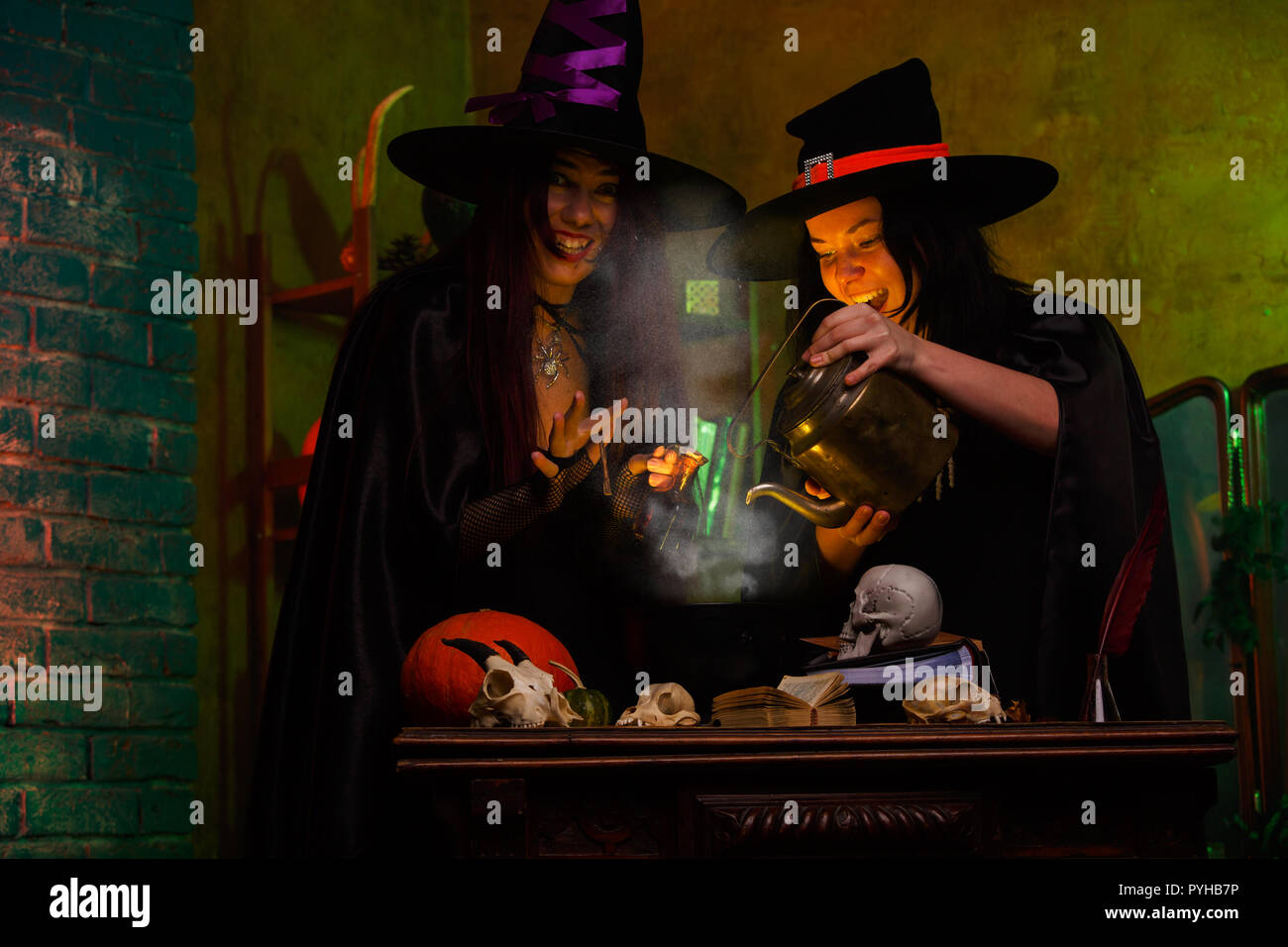 Photo of witches with pot of magic poison and steam Stock Photo