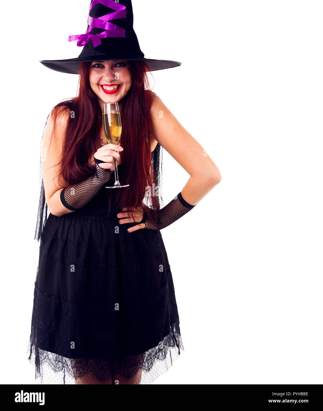 Portrait of laughing witch in black hat, with glass of champagne Stock Photo