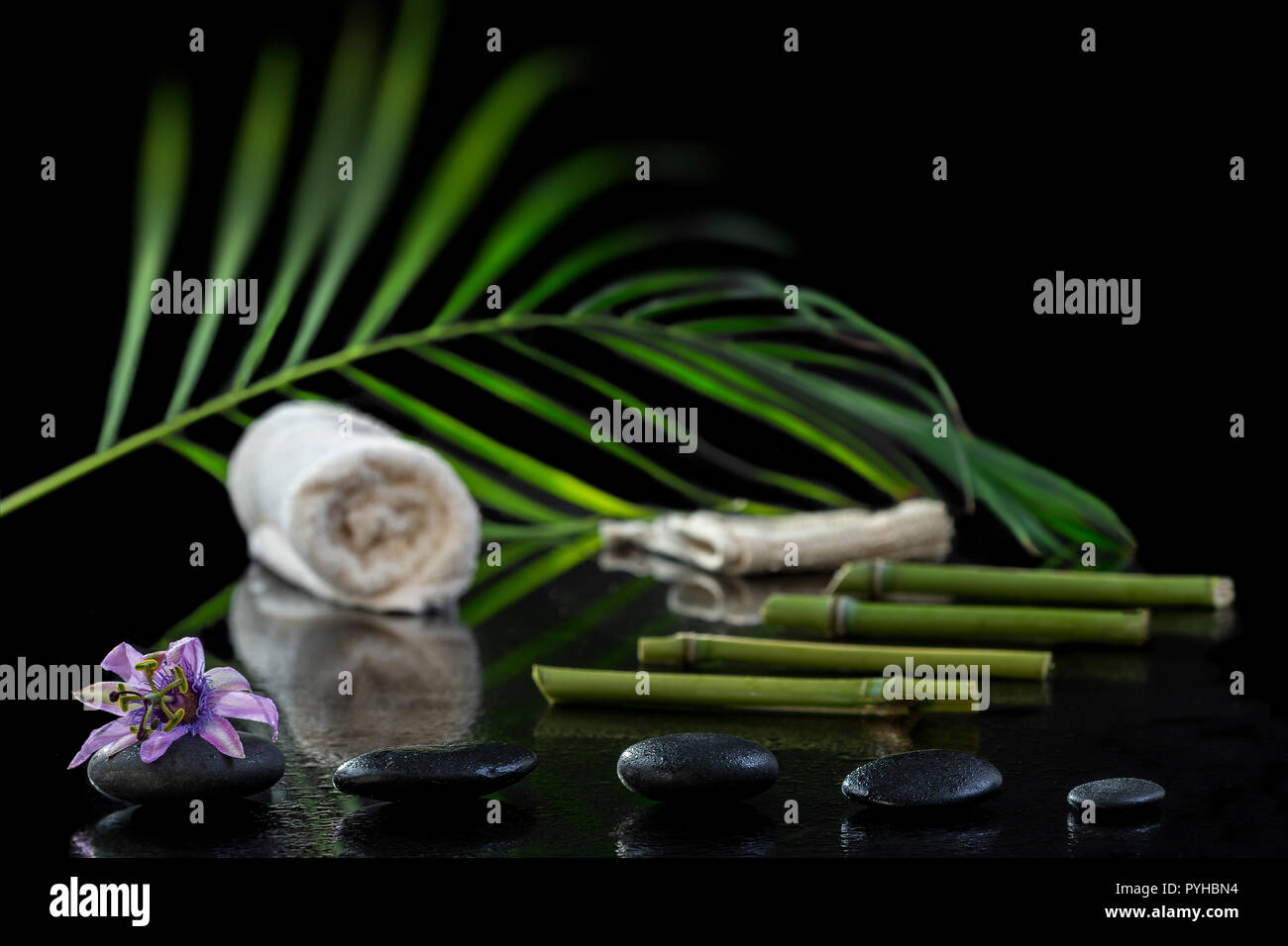 Beautiful spa composition with passiflora, bamboo and stones on black Stock Photo
