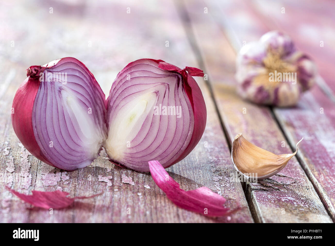 Beautiful fresh cut red onions, and pink garlic. Group of objects or cooking ingredients, isolated on pink Stock Photo