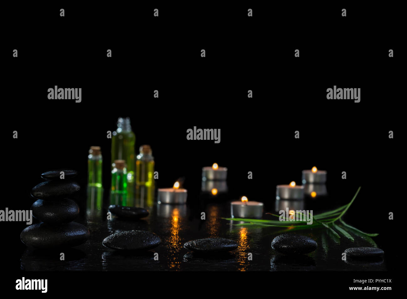 spa concept, wellness, relaxation, lighted candles, hot stones, on black, spa treatment Stock Photo