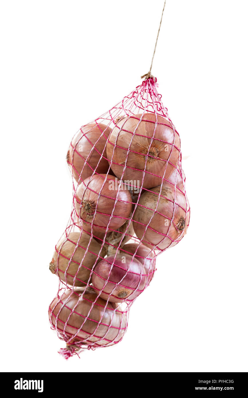 pink onion hanging packed in a red net bag on white background Stock Photo