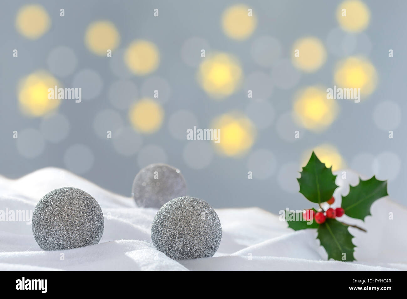 Christmas Decoration with silver, three Balls in the Snow on the Blurred Lights Background Greeting Card Stock Photo