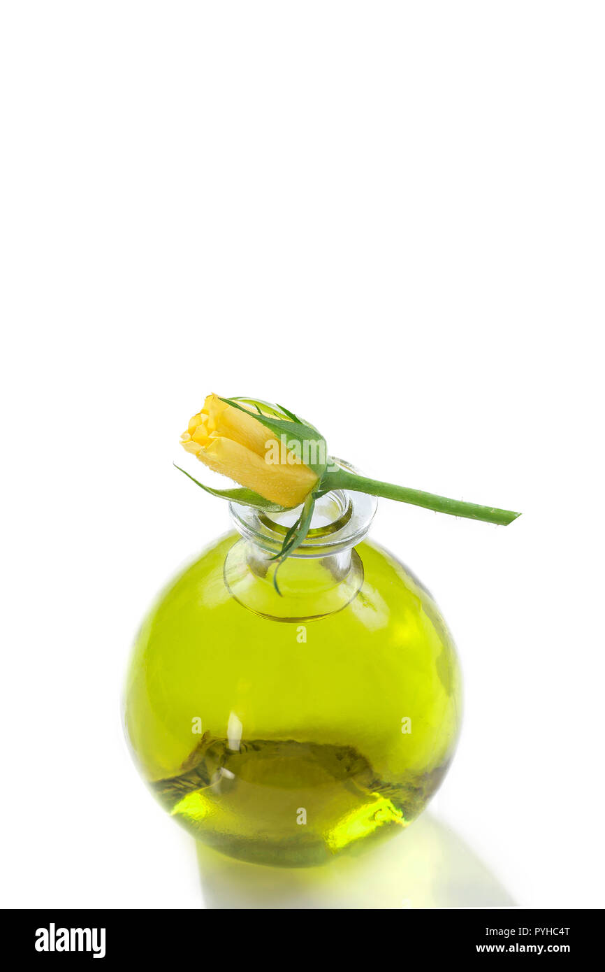 Essential oils bottles with fresh yellow roses on top, Botanical treatment aromatherapy Stock Photo