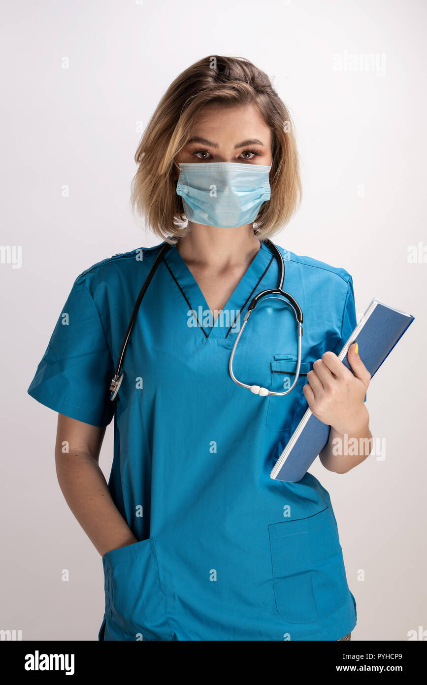 Portrait of young doctor with stethoscope wearing face mask holding