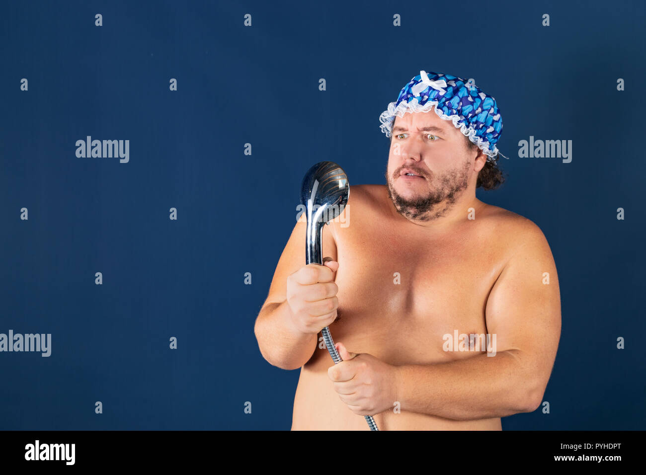 Funny fat man in blue cap sing in the shower. Fun and cleanliness Stock Photo