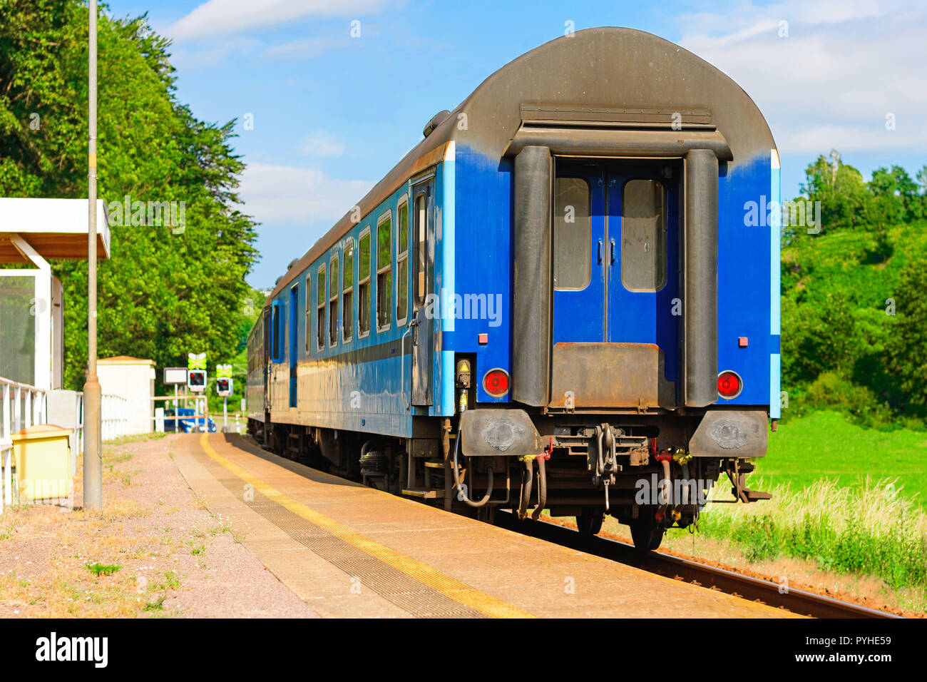 Blue rail wagon waits at the platform for passengers. Rail transport in the Czech Republic. Empty platforms at the regional station. A sunny day on th Stock Photo