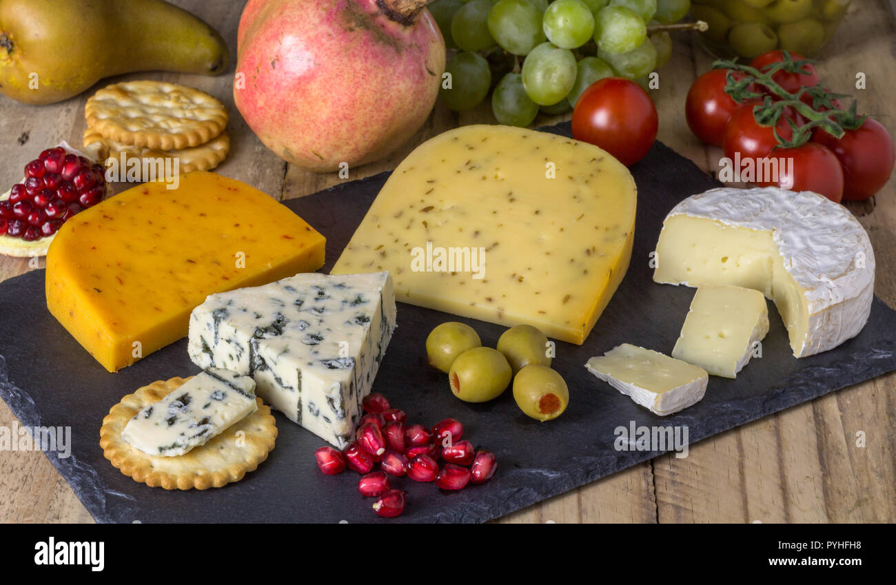 Cheese board with three cheeses, gouda with pimento, gouda with cumin