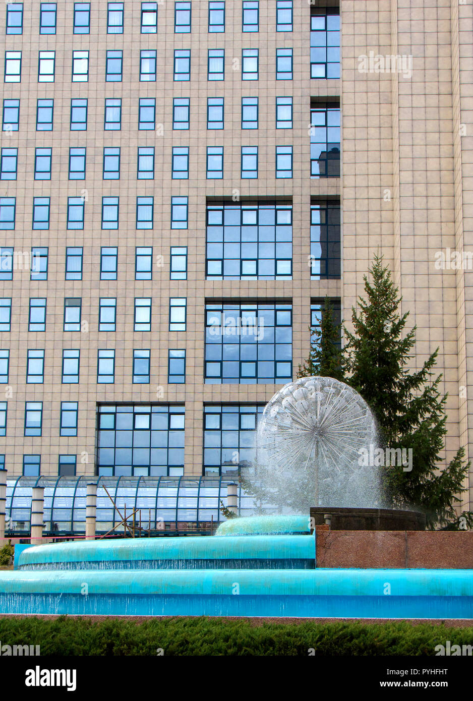 Modern style office building, with a fountain located in front of the building Stock Photo
