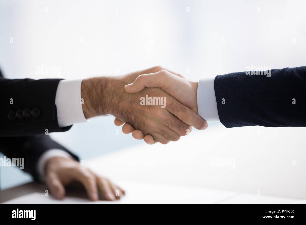 Two men in suits are shaking hands. Close up, concept Stock Photo