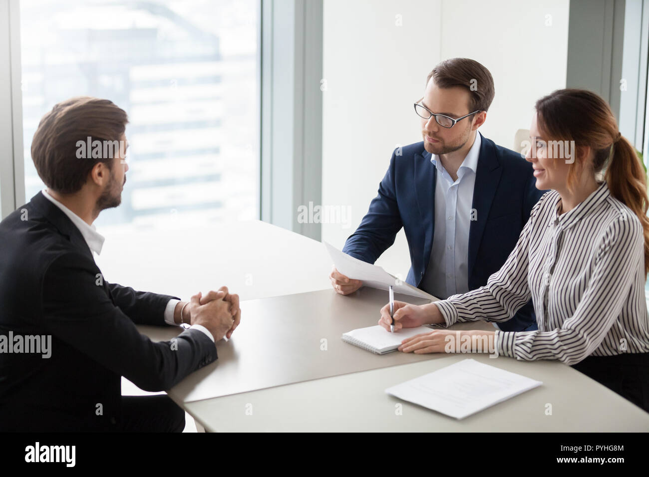 Two hr managers talking with candidate for vacancy. Stock Photo