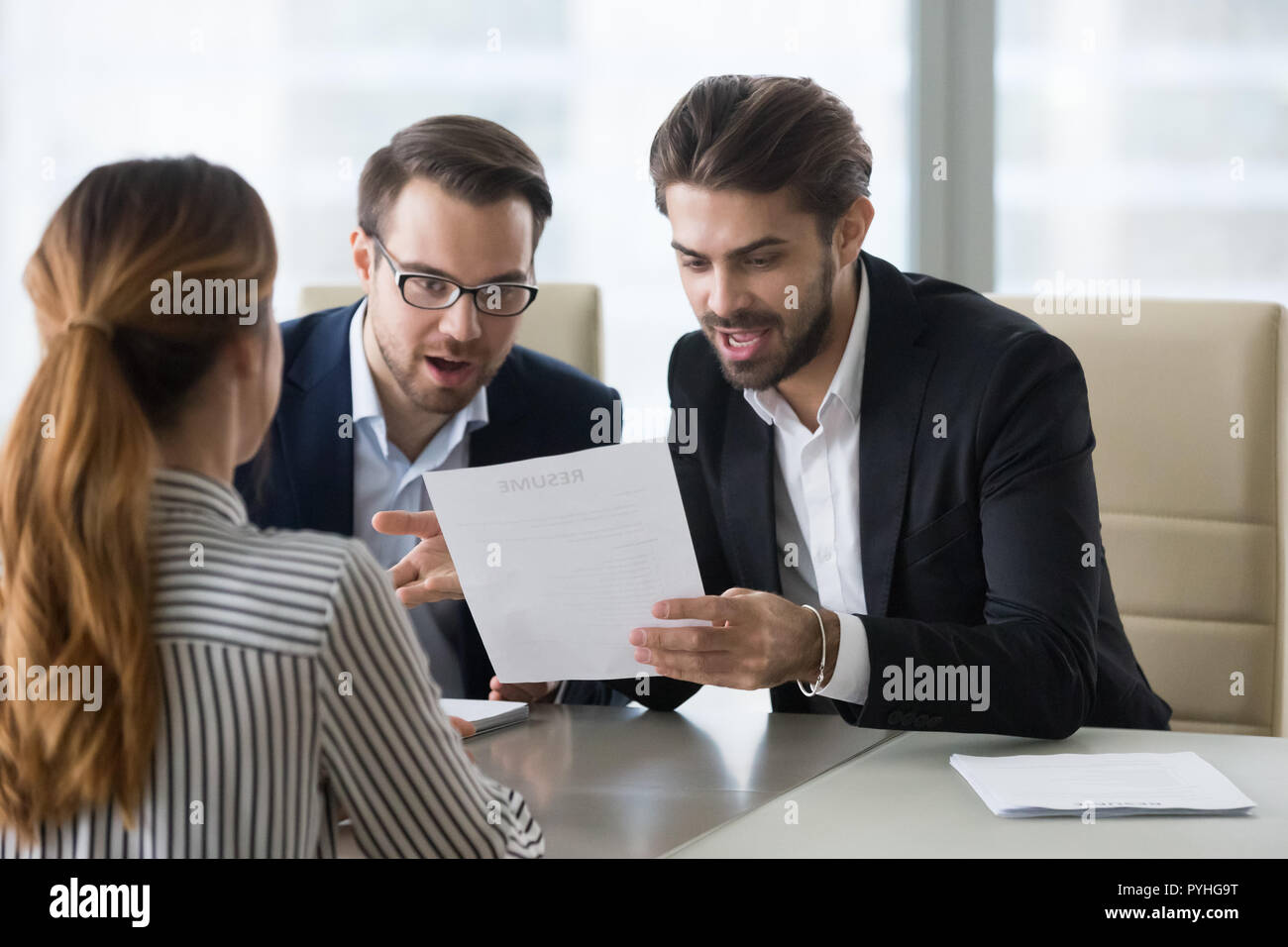 Pleasantly surprised hr managers reading resume of applicant. Stock Photo