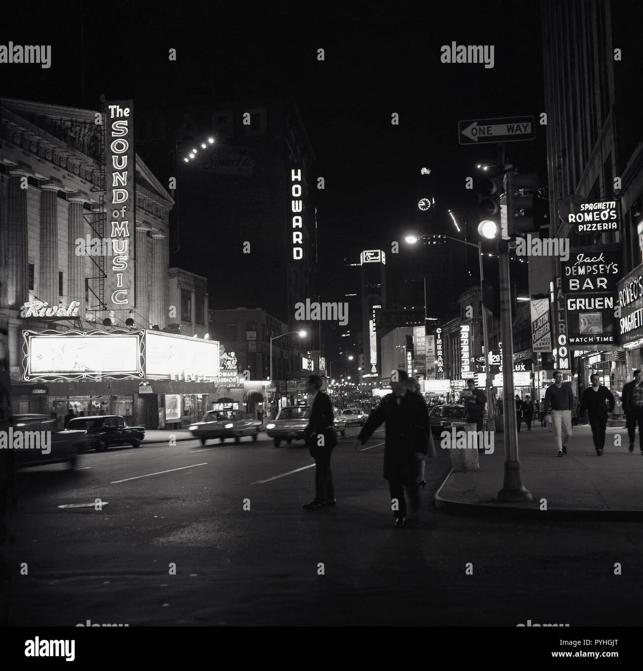 1959, historical, nightime on Broadway, midtown Manhattan and the neon lights showing the bars and restaurants and the original production of The Sound of Music, a musical by Rodgers and Hammerstein, based on the memoir of Maria von Trapp, staring Mary Martin and Theodore Bikel. On the right is Jack Dempsey's, the bar and restaurant owned by the former world Heavyweight boxing champion and a cultural icon of the 1920s. Stock Photo