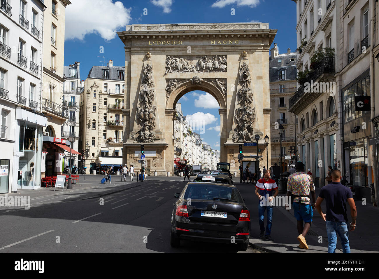 Paris, Ile-de-France, France - View from the Rue Saint-Denis in the 10th arrondissement to the monument Porte Saint-Denis, a monument in the form of a triumphal arch. Stock Photo