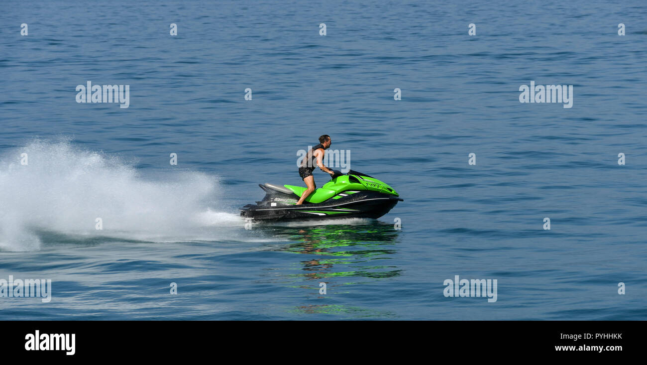 LAKE GARDA, ITALY - SEPTEMBER 2018: Person riding a fast jet ski skimming the surface of Lake Garda. Stock Photo