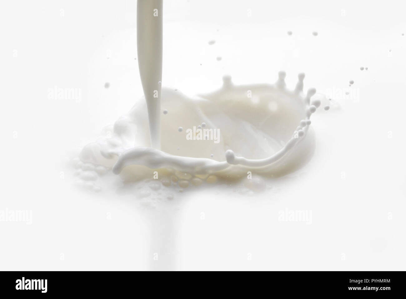 Pouring milk splash on white background macro Stock Photo - Alamy
