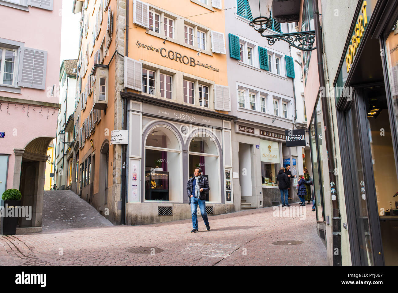 Zurich, Switzerland - March 2017: People walking in posh Glockengasse high street, a small medieval alley with elegant shops in Zurich city centre, Sw Stock Photo