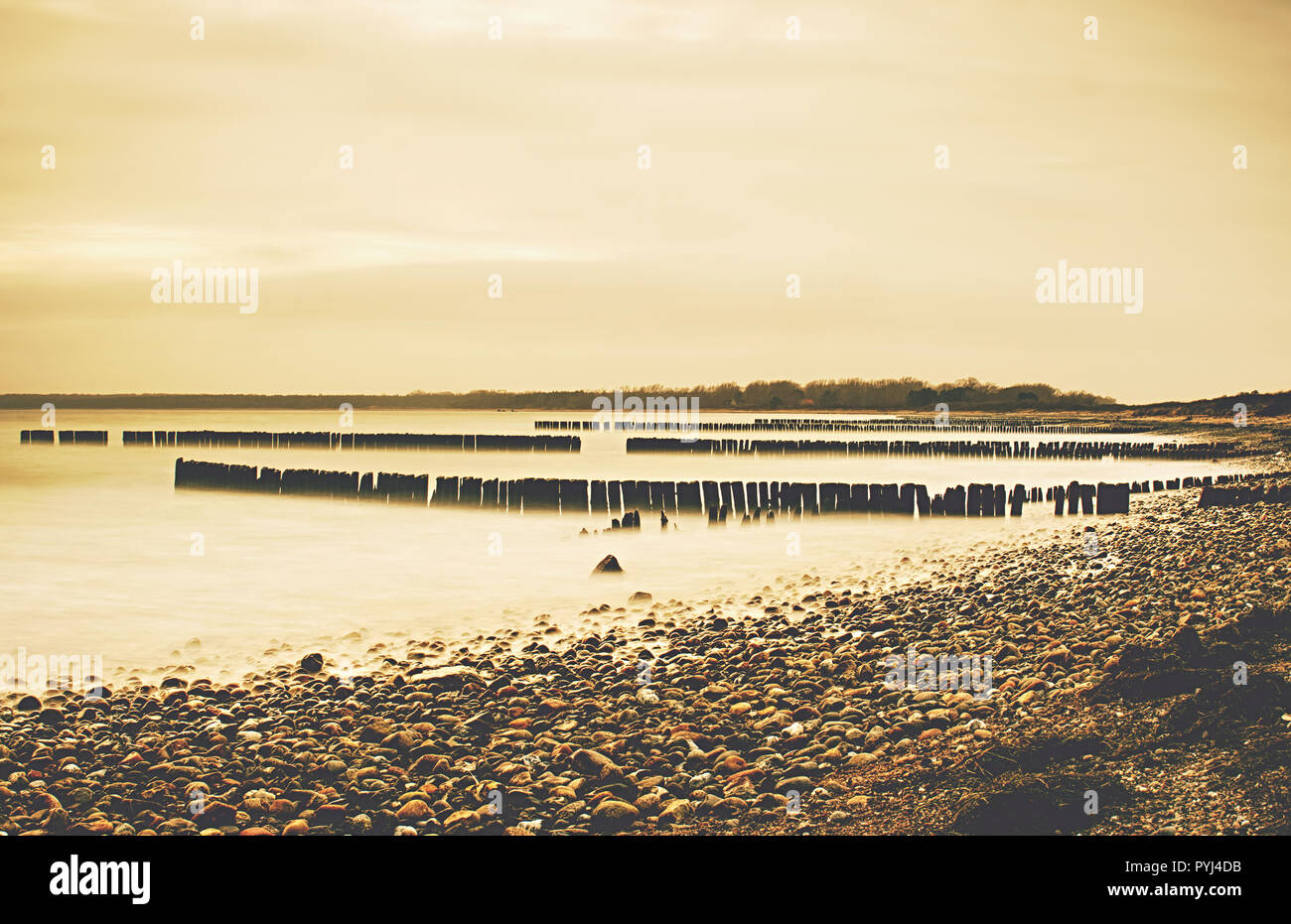 Long exposure at sunset of pier pilings. Breakwater built of wooden ...