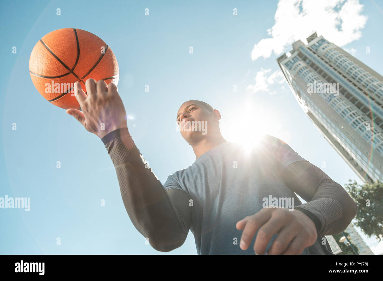 Low angle of a nice young man rotating the ball Stock Photo