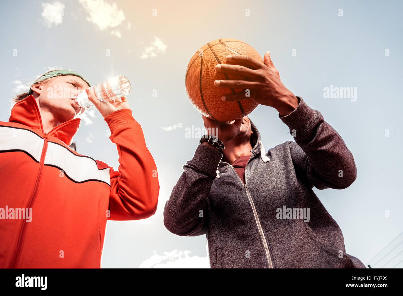 Low angle of a basketball ball in male hands Stock Photo