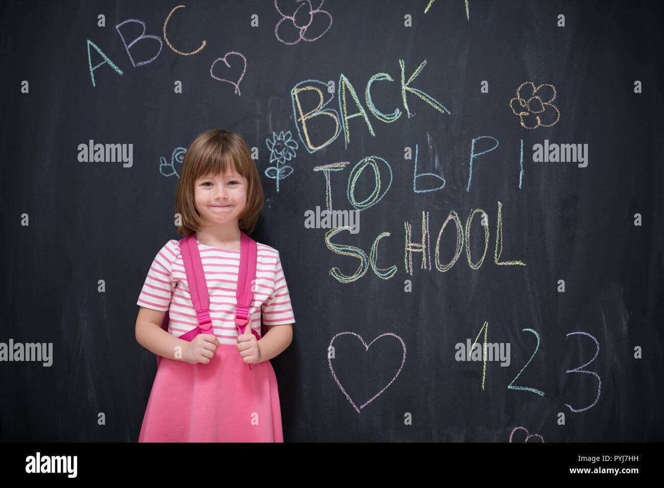 Happy school girl child with backpack writing back to school on black ...