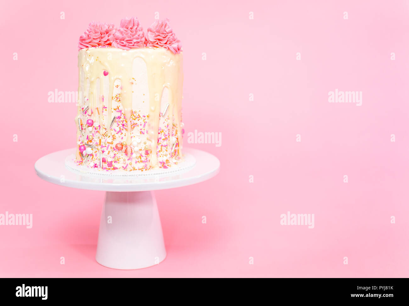 Pink and white buttercream cream cake with pink sprinkles and white ...