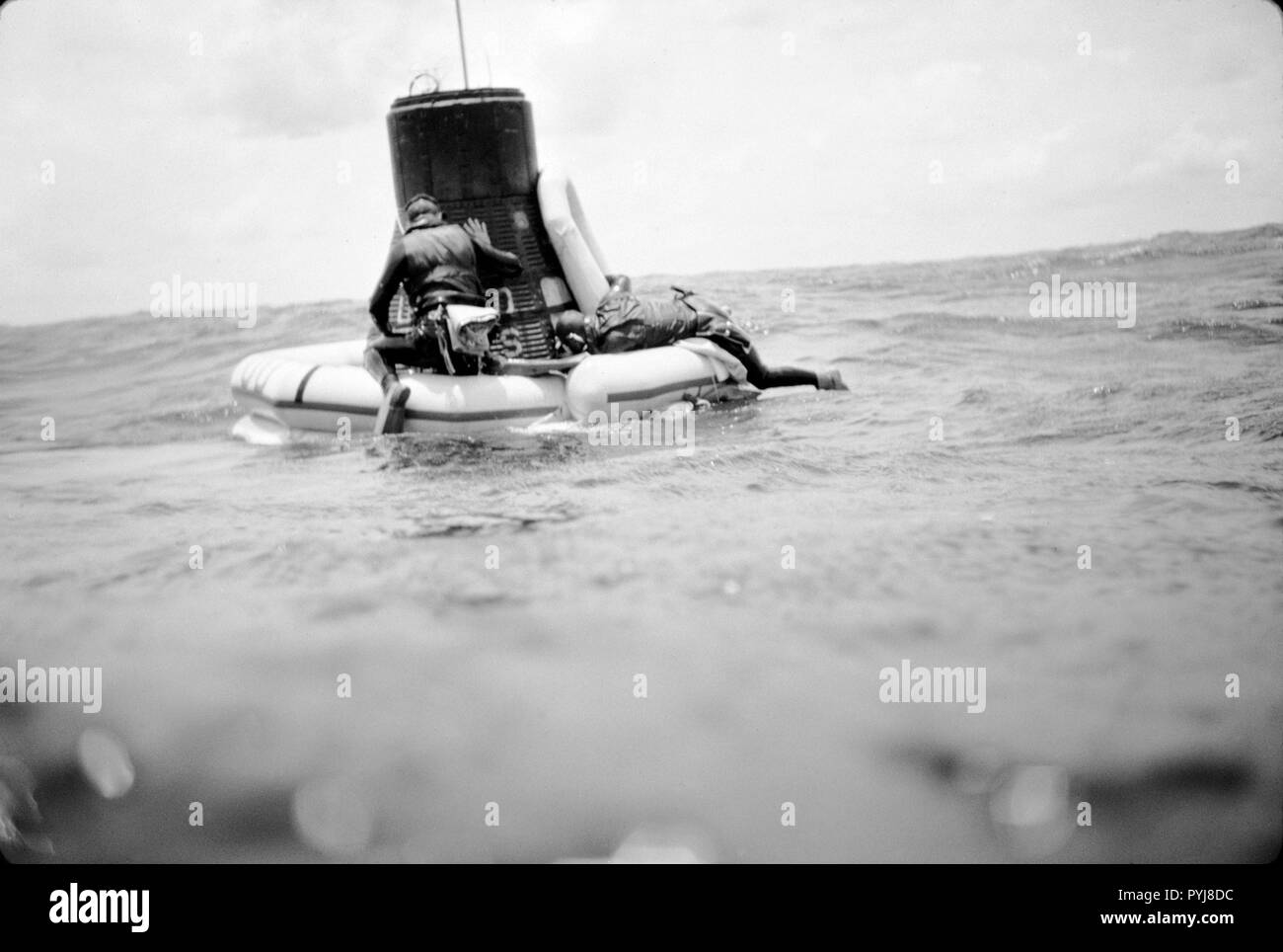 (16 May 1963) --- A U.S. Navy frogman team attaches a flotation collar to the Mercury-Atlas 9 (MA-9)'Faith 7' spacecraft during recovery operations in the central Pacific near Midway Island. Stock Photo