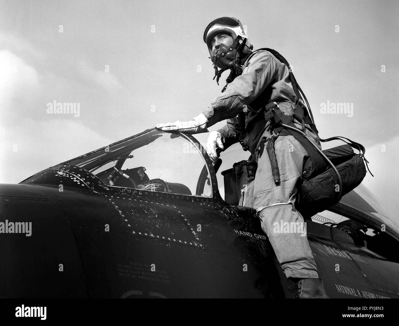 Pilot Joe Algranti climbs into the cockpit of a McDonnell F2H-2B Banshee on the tarmac at the National Advisory Committee for Aeronautics (NACA) Lewis Flight Propulsion Laboratory. Stock Photo
